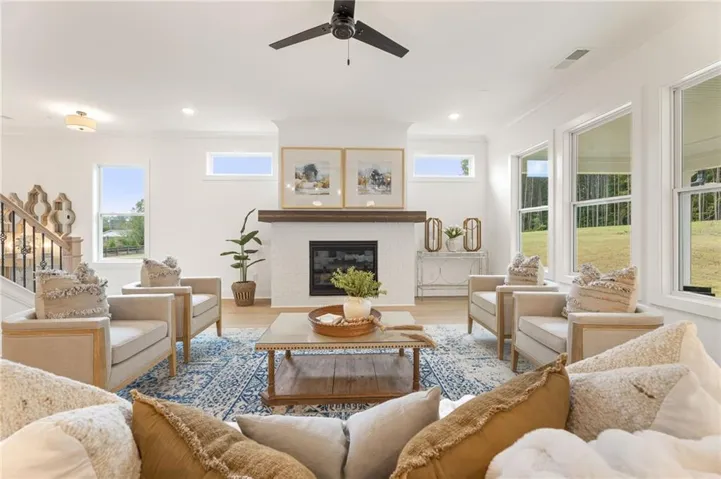 White brick fireplace with a wood mantel, wood-finish flooring, recessed lighting, and a dark-toned ceiling fan