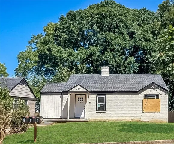 White brick exterior with a dark shingle roof