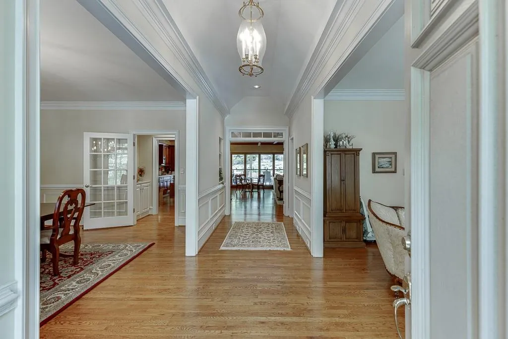 Foyer featuring an inviting chandelier, light wood-type flooring, and crown molding
