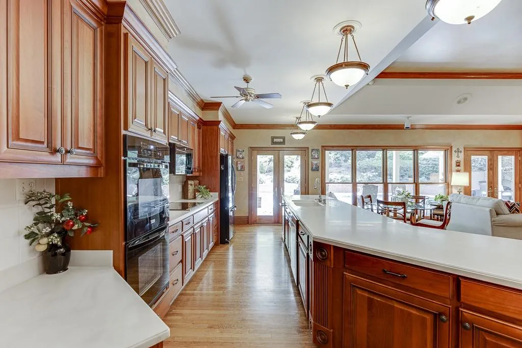 Kitchen with ceiling fan, black appliances, french doors, and a wealth of natural light