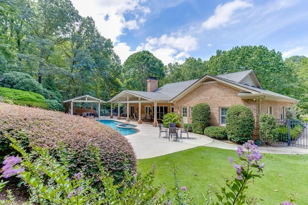 Rear view of house with a fenced in pool, a patio area, and a yard