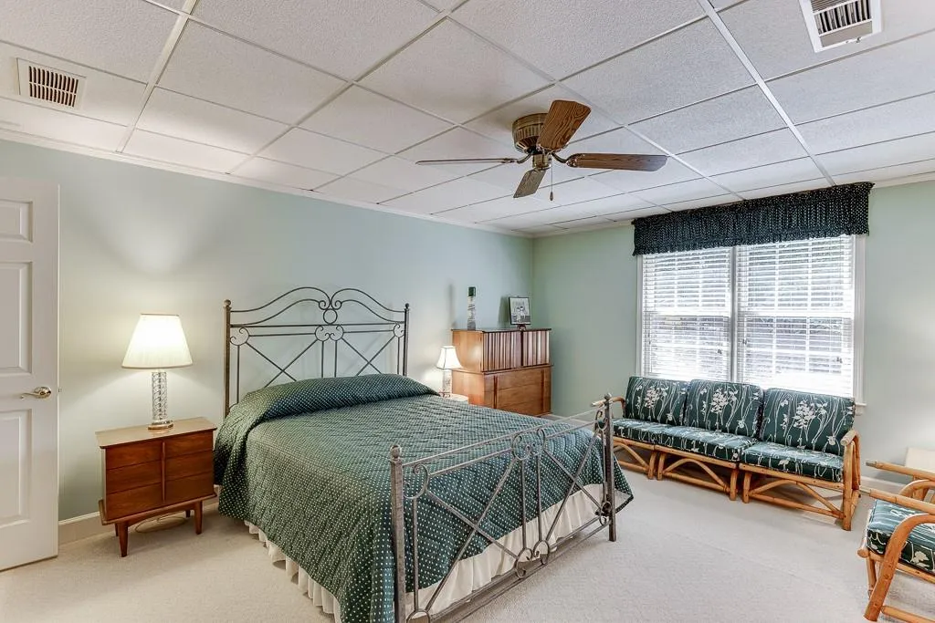 Bedroom with ceiling fan, carpet floors, and a paneled ceiling