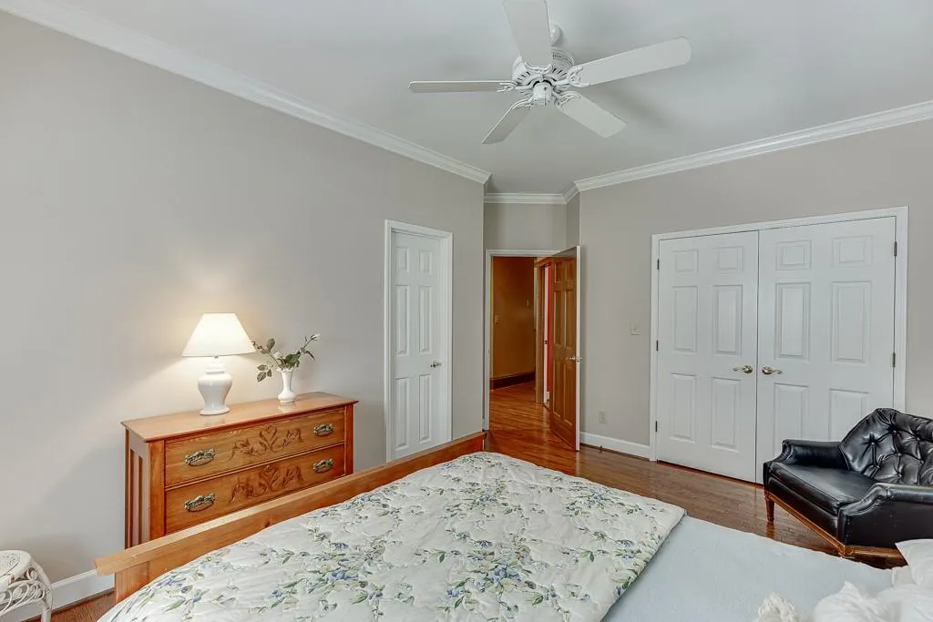 Bedroom featuring ceiling fan, hardwood / wood-style flooring, a closet, and crown molding