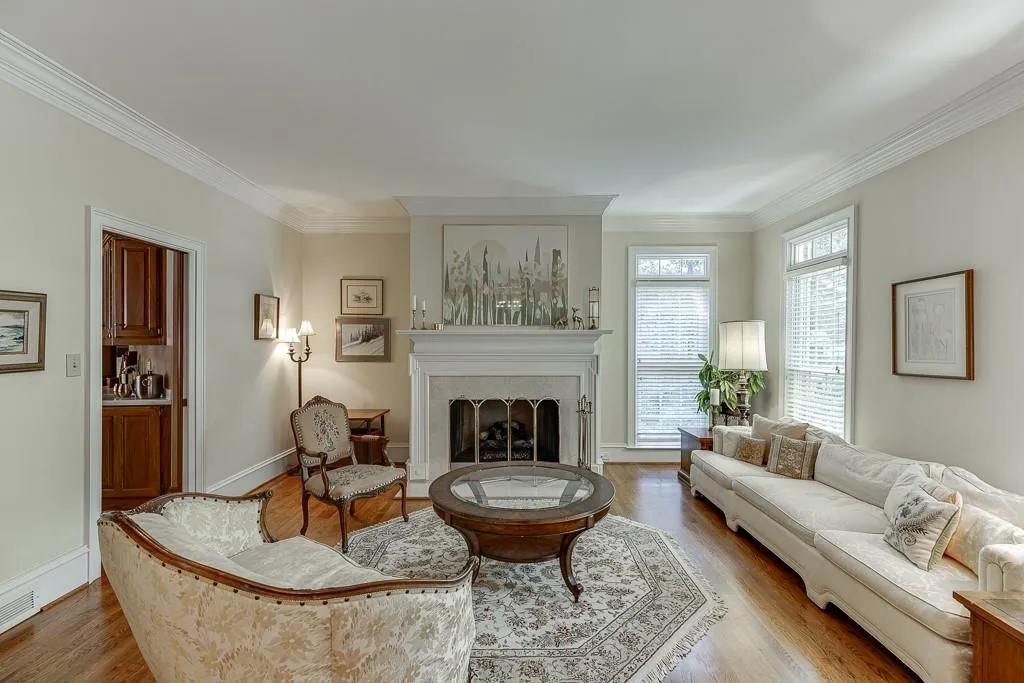 Living room featuring a fireplace, crown molding, and hardwood / wood-style floors