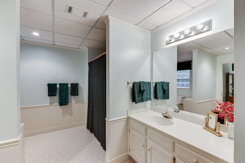 Bathroom featuring a shower with curtain, a paneled ceiling, vanity, and tile patterned floors