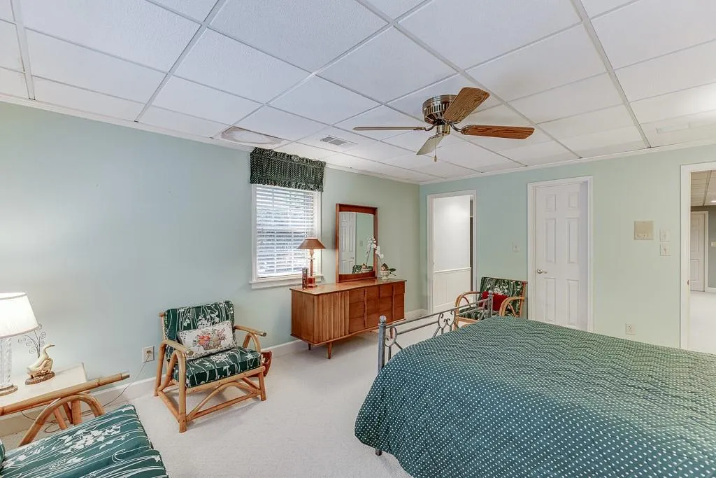 Bedroom featuring a drop ceiling, carpet, and ceiling fan