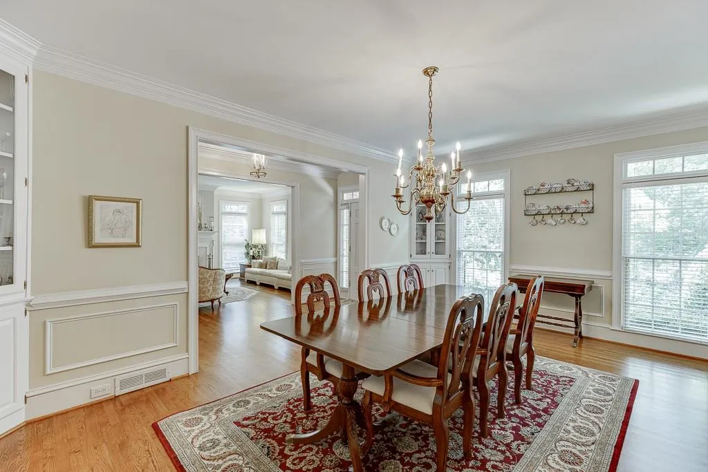 Dining area featuring light wood-type flooring, a chandelier, and ornamental molding