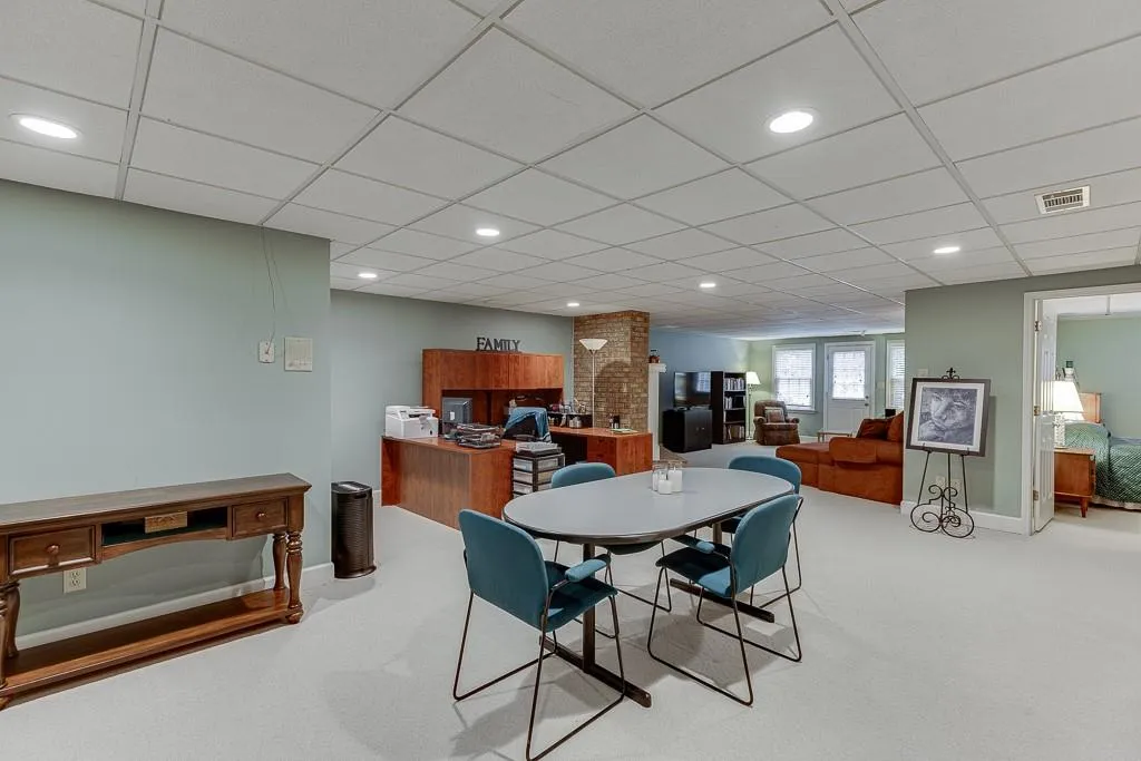 Carpeted dining room featuring a paneled ceiling