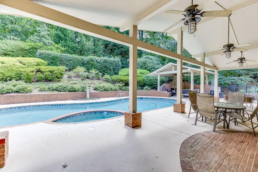 View of pool with ceiling fan and a patio area