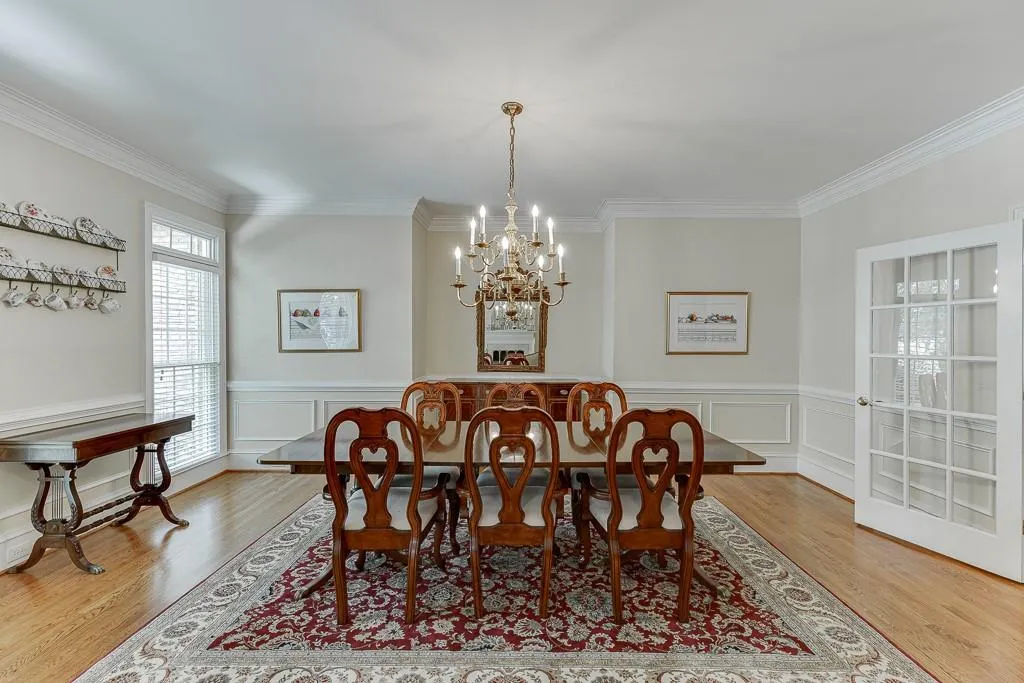 Dining area with crown molding, light hardwood / wood-style flooring, and a notable chandelier