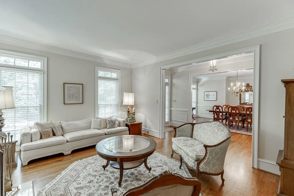 Living room featuring ornamental molding, a chandelier, light hardwood / wood-style floors, and a healthy amount of sunlight