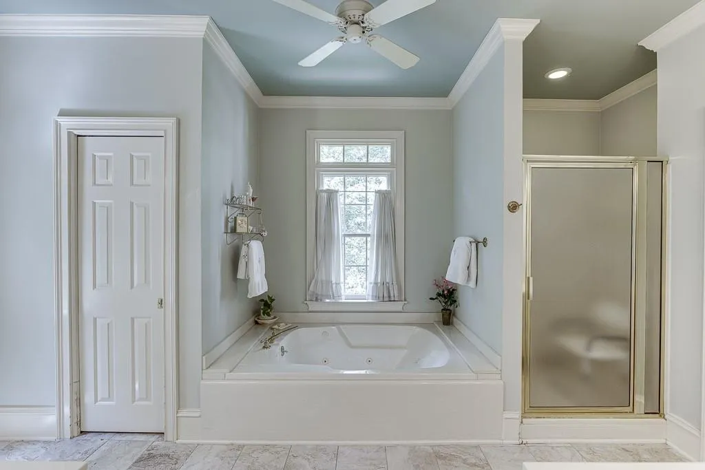 Bathroom with shower with separate bathtub, ornamental molding, and ceiling fan