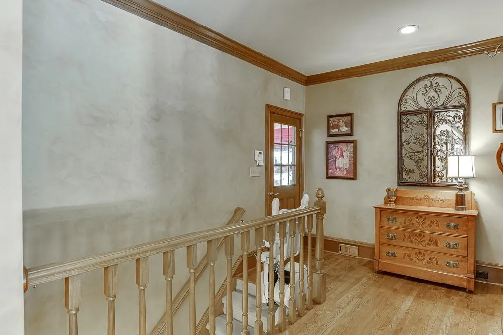 Hallway featuring light wood-type flooring and crown molding
