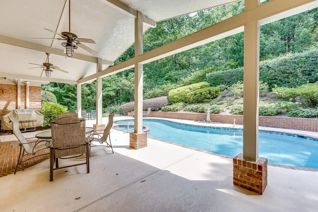 View of swimming pool with ceiling fan and a patio