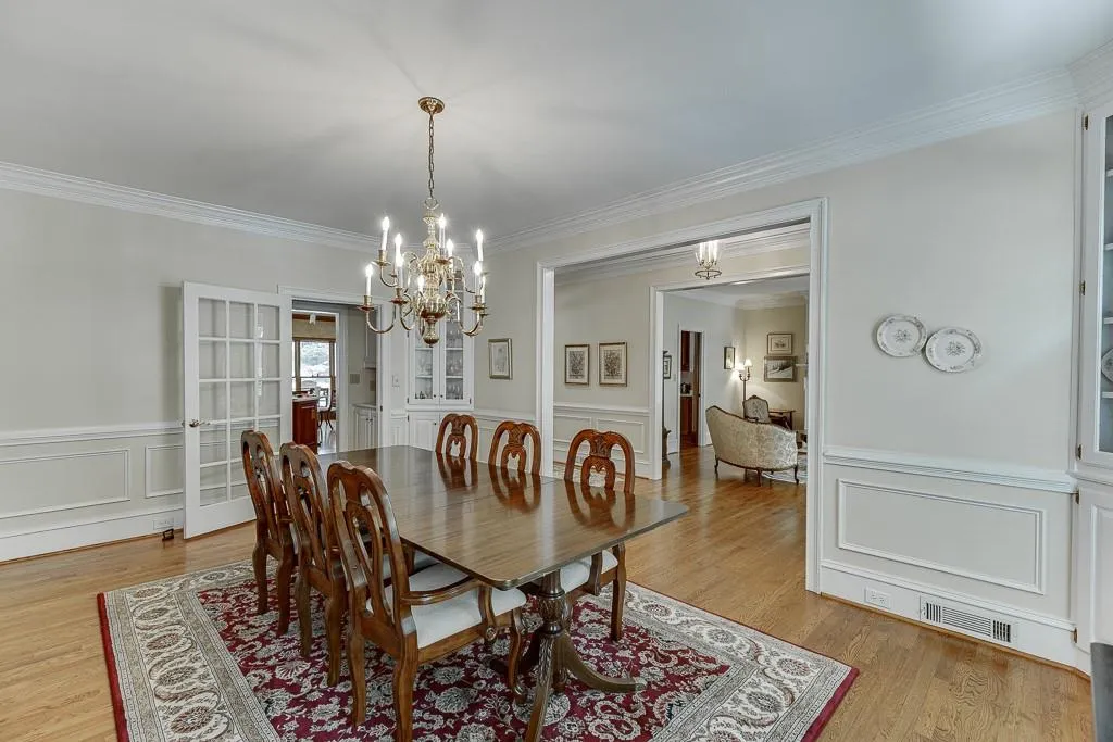 Dining room with ornamental molding, a notable chandelier, and light hardwood / wood-style floors
