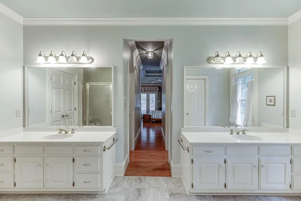 Bathroom with ornamental molding, vanity, hardwood / wood-style floors, and a shower with shower door