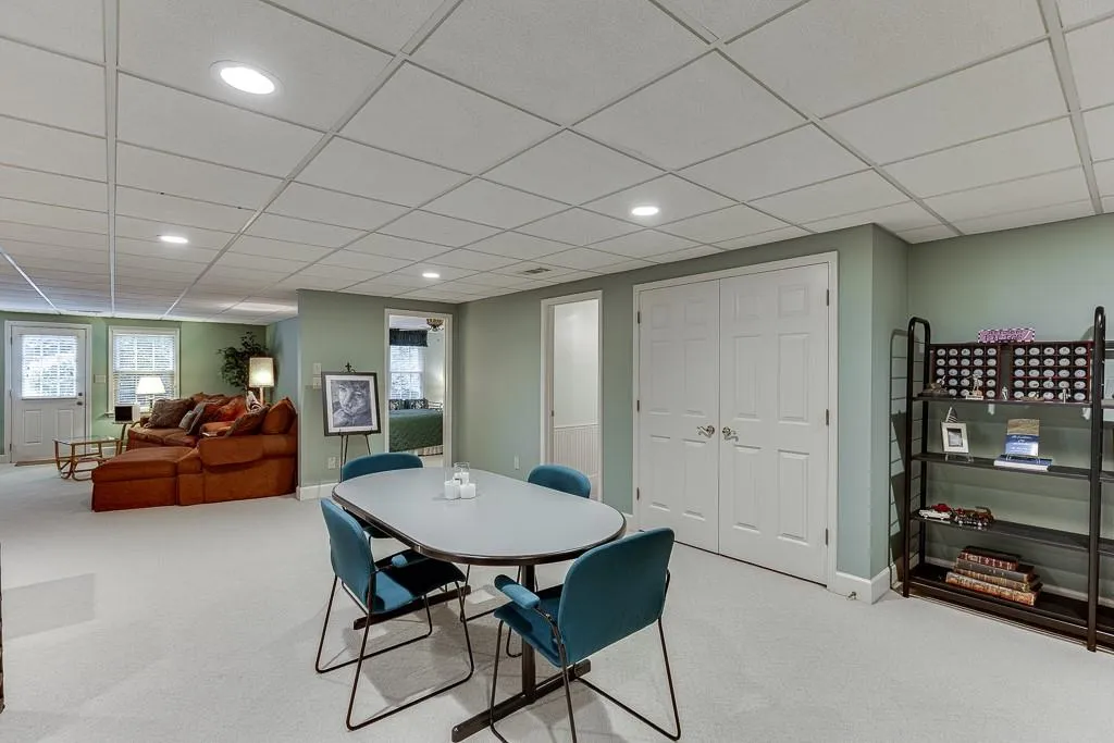 Dining space with light carpet and a paneled ceiling