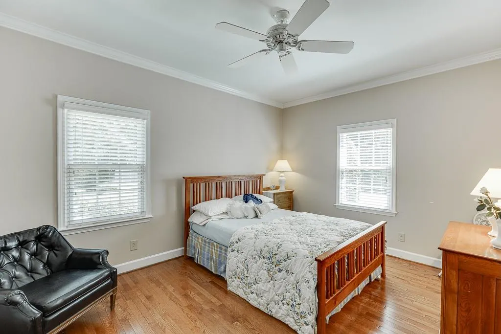 Bedroom featuring ceiling fan, light hardwood / wood-style flooring, and ornamental molding
