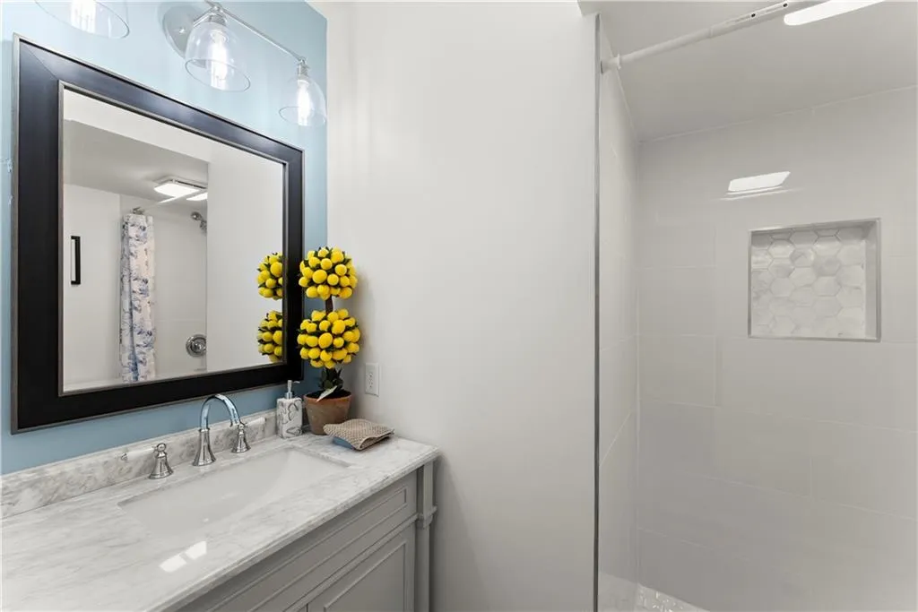 Full bath featuring vanity and a tile shower