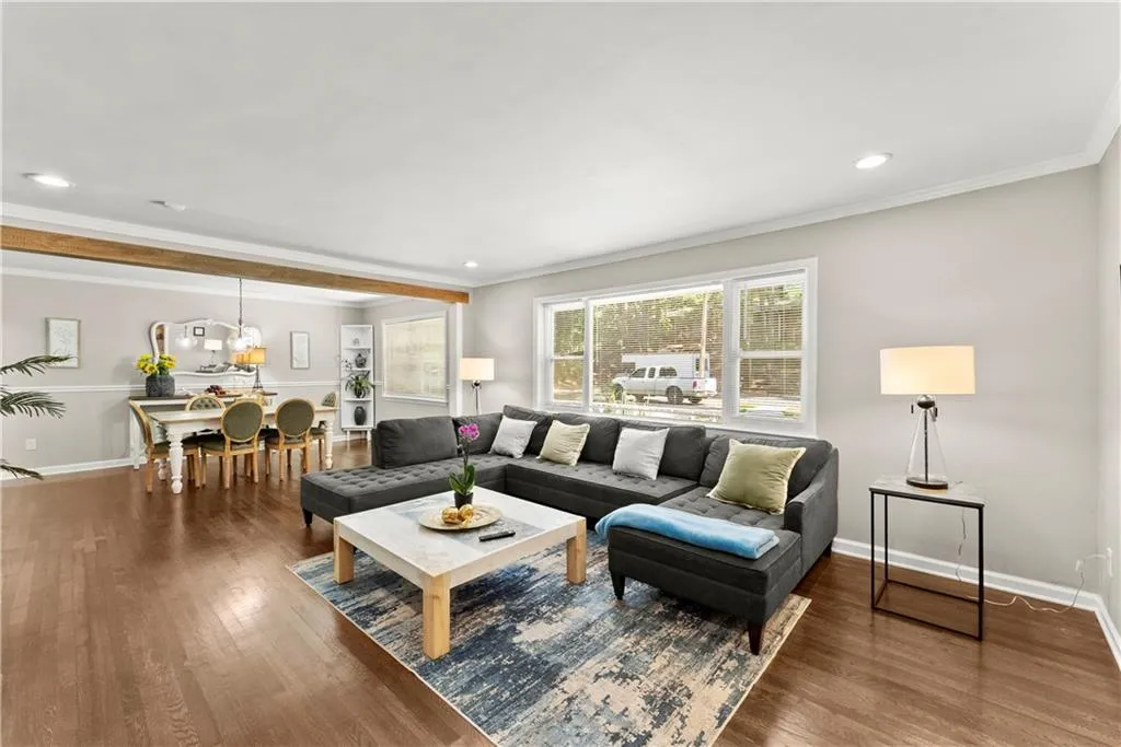 Living room with ornamental molding, wood finished floors, and recessed lighting