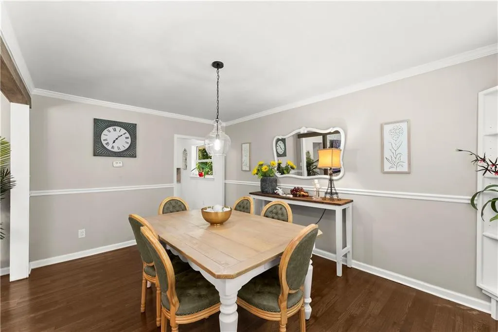 Dining area featuring crown molding and dark wood-style floors