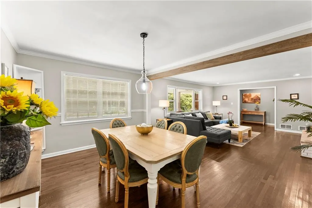 Dining area featuring crown molding and dark wood-style flooring