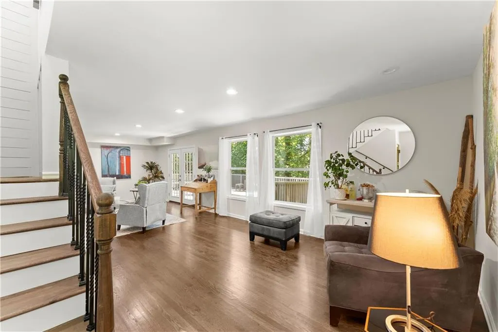 Living room with stairway, wood finished floors, recessed lighting, and french doors
