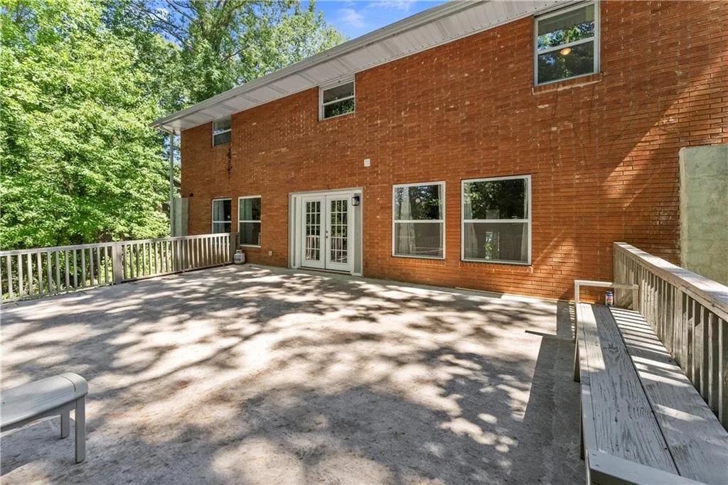 Rear view of property with brick siding and french doors