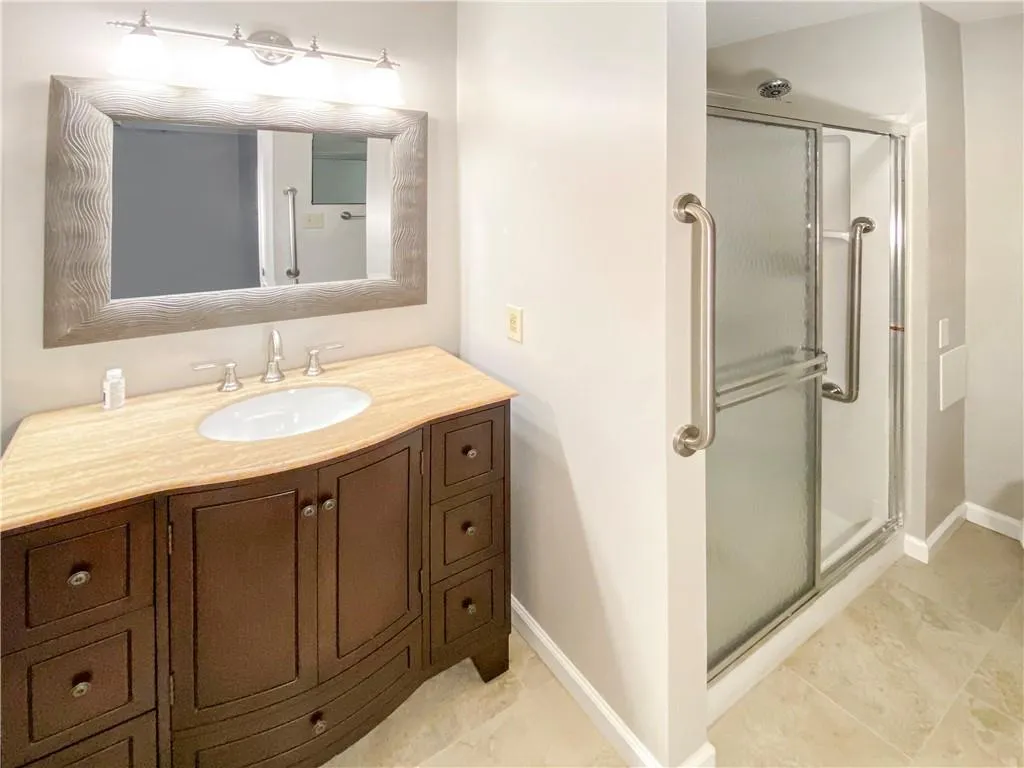 Bathroom featuring vanity, tile patterned flooring, and an enclosed shower