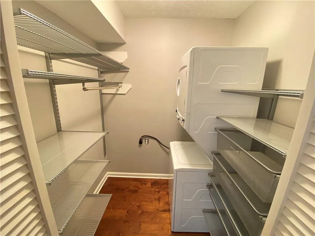 Walk in closet featuring over under private laundry.