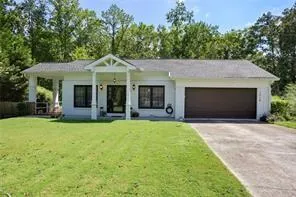 View of front facade featuring a front lawn and a garage