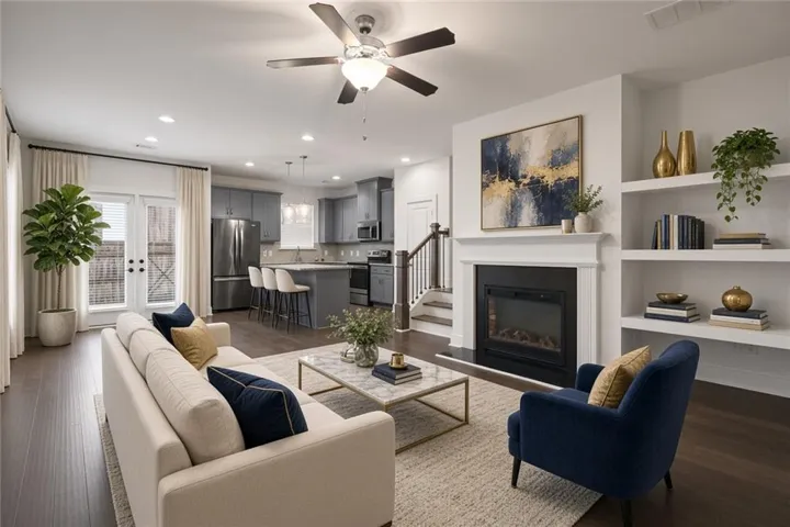 Virtually Staged - Open-concept living area featuring wood-finish flooring, a built-in fireplace with mantel, recessed lighting, and integrated shelving