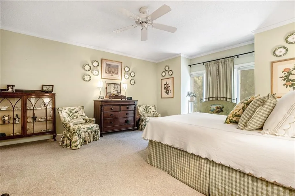 Carpeted bedroom with crown molding and a ceiling fan Carpeted bedroom with crown molding and a ceiling fan