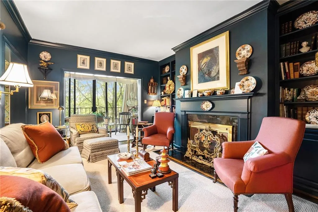 Living area featuring ornamental molding, a premium fireplace, built in shelves, and carpet Living area featuring ornamental molding, a premium fireplace, built in shelves, and carpet