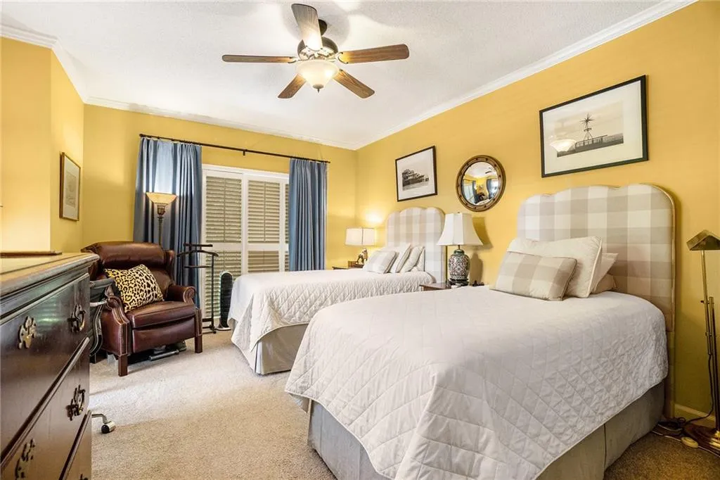 Bedroom with light colored carpet, crown molding, a textured ceiling, and a ceiling fan Bedroom with light colored carpet, crown molding, a textured ceiling, and a ceiling fan