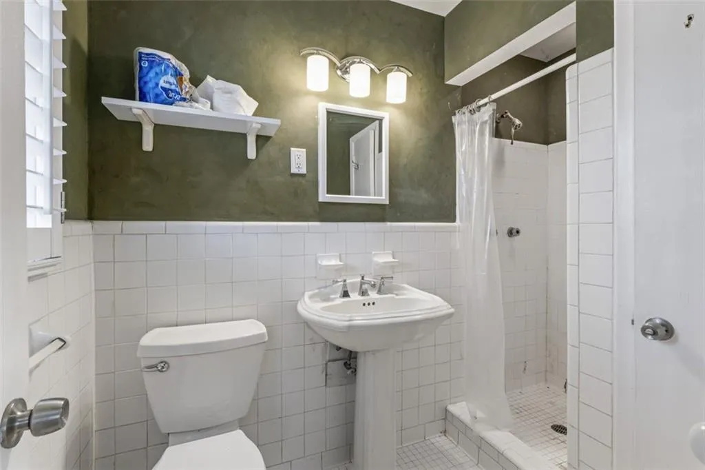 Master bathroom with tile walls, toilet and shower.