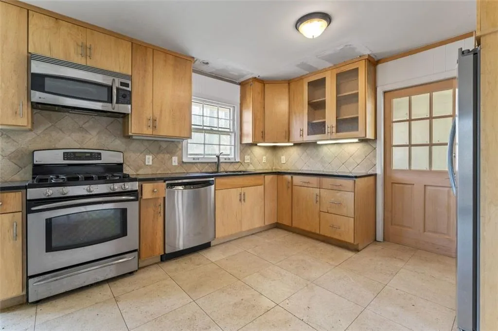 Kitchen featuring stainless steel appliances  and backsplash.