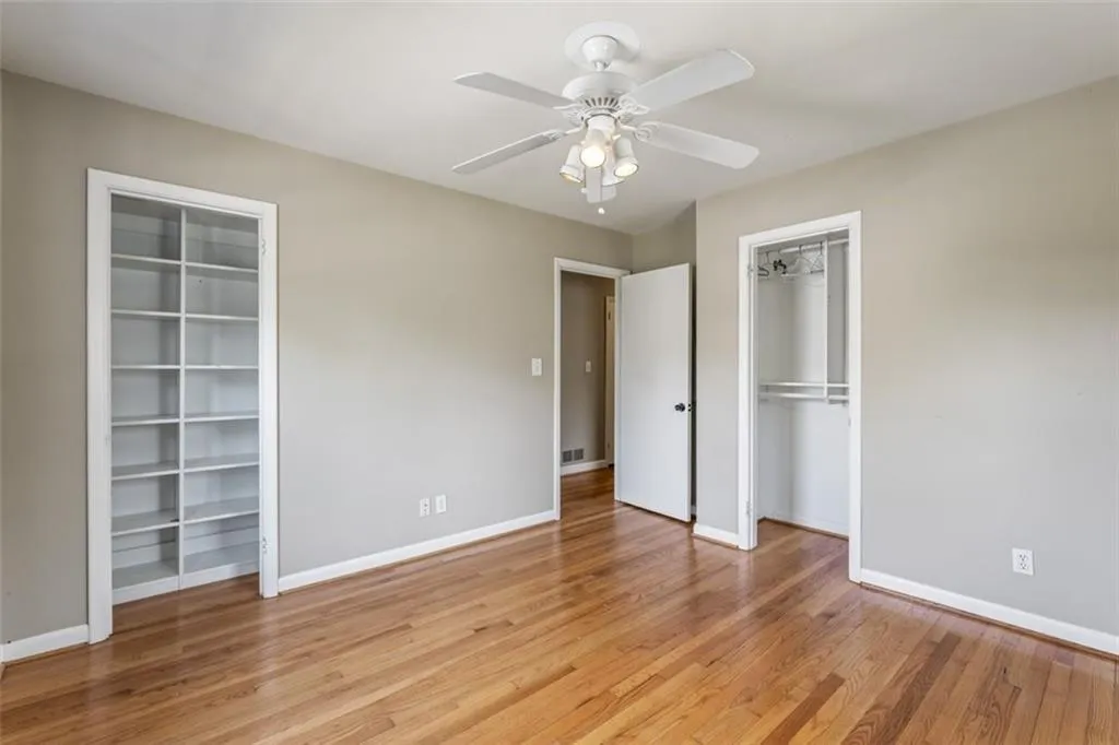 Bedroom with light hardwood floors, 2 closets and ceiling fan