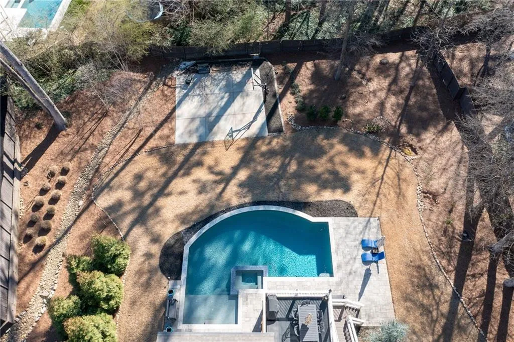 Fenced yard with pool and sports court