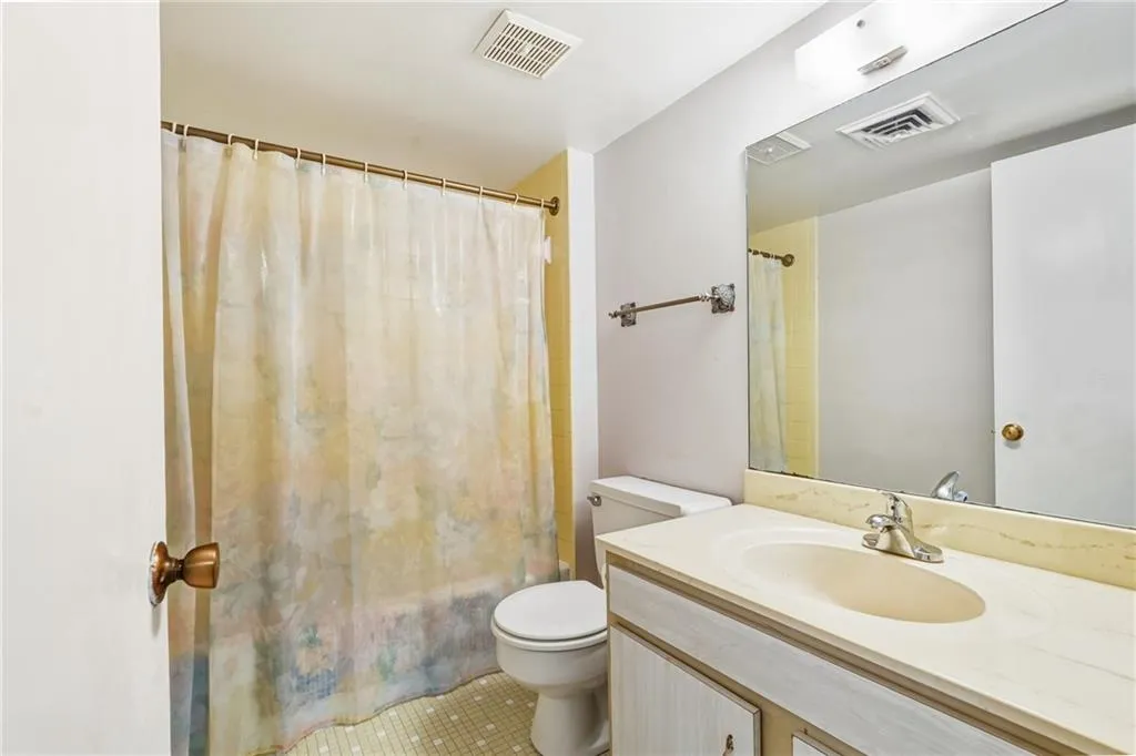 Full bathroom with vanity, shower / bath combination with curtain, and tile patterned flooring
