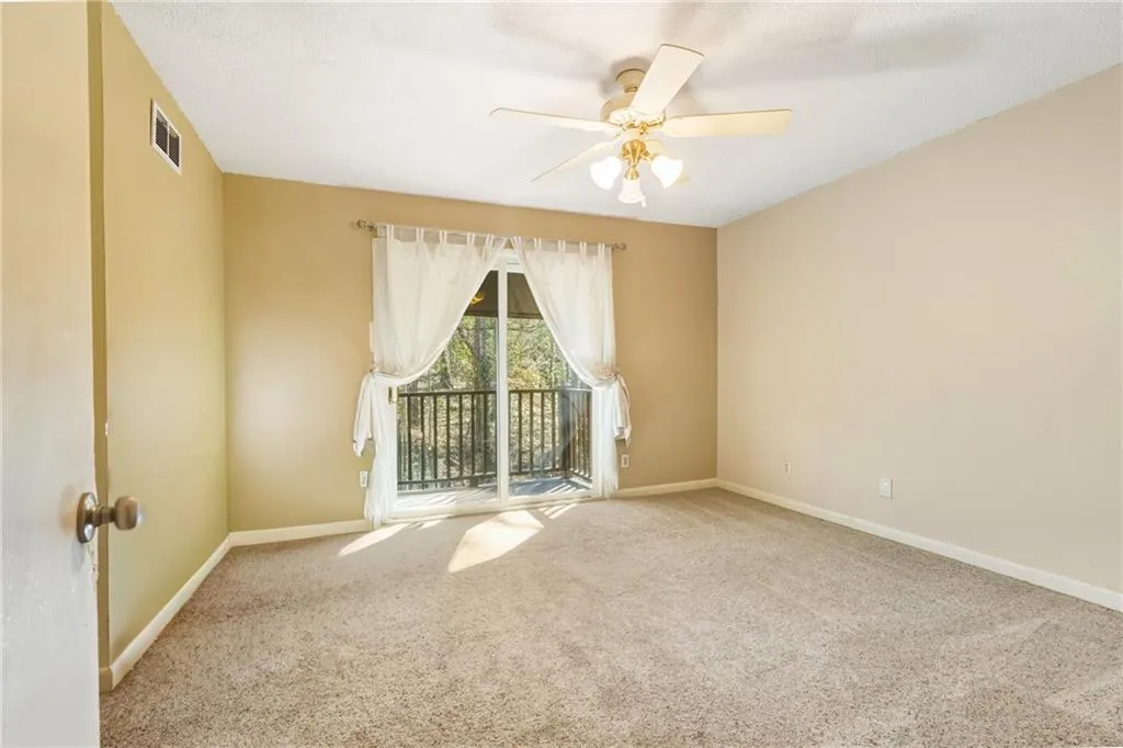 Spare room featuring carpet and a ceiling fan