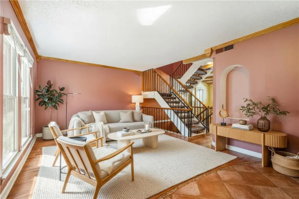 Living area featuring crown molding, wood finished floors, and a textured ceiling