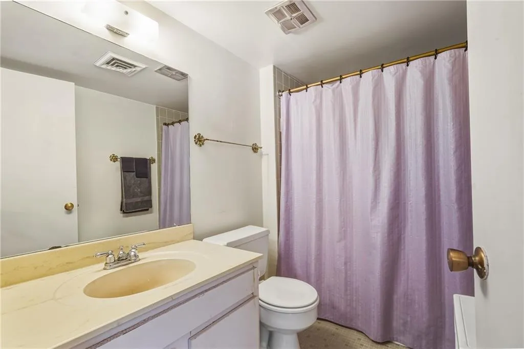 Full bath featuring vanity and curtained shower