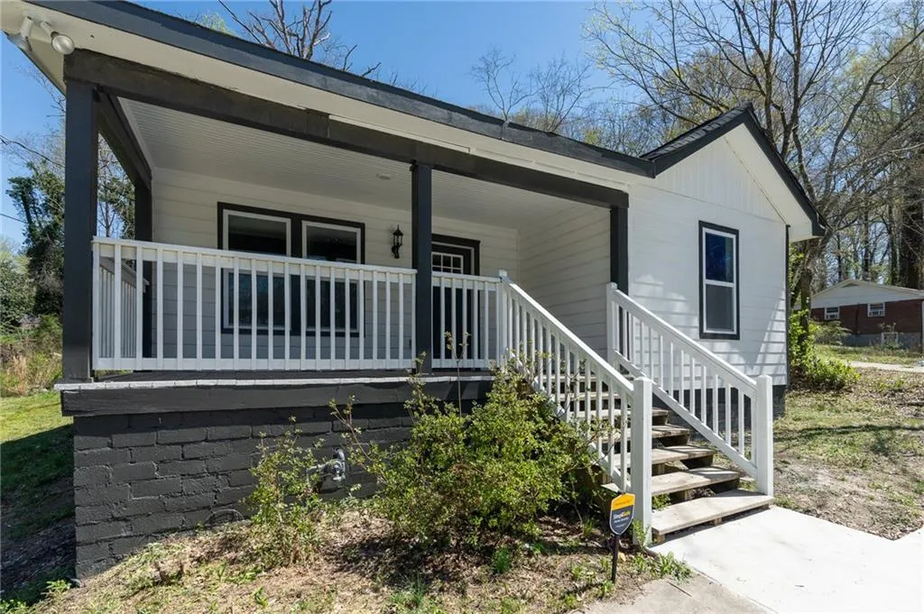 View of front of property featuring a porch and stairs