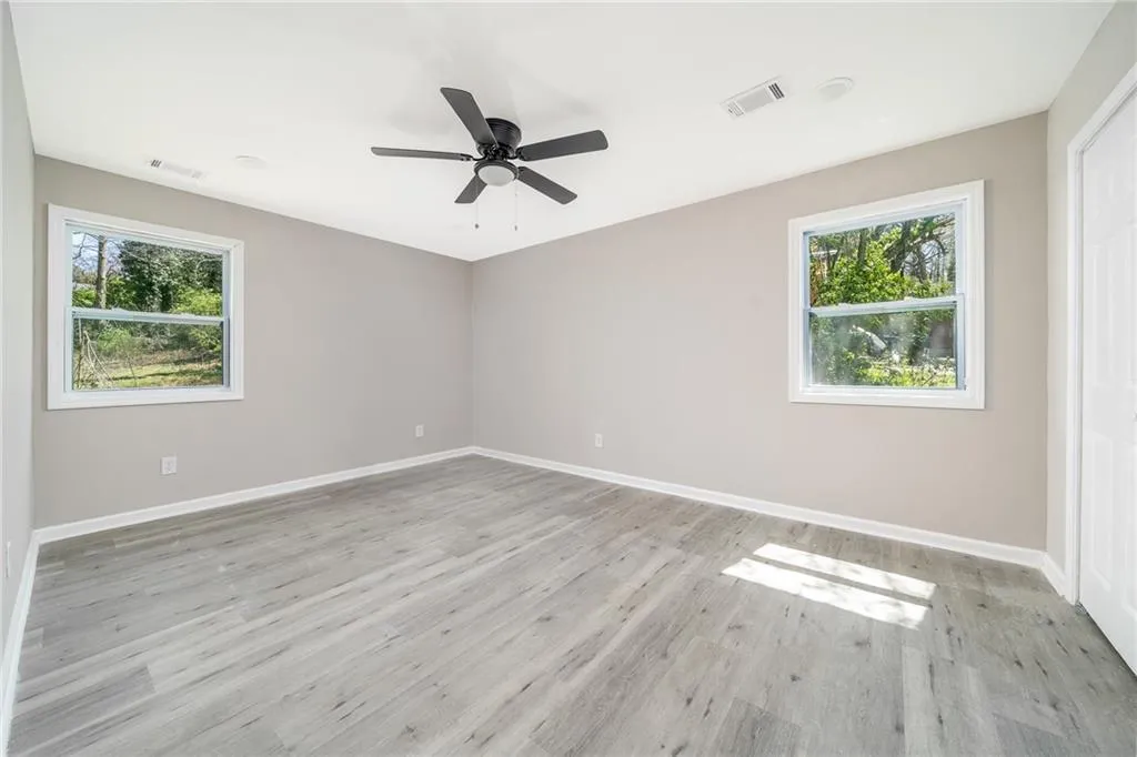 Empty room with light wood-style floors and ceiling fan