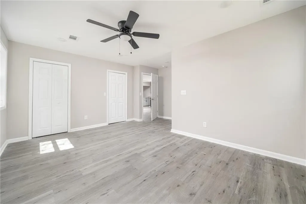 Unfurnished bedroom featuring light wood-style flooring, a ceiling fan, and a closet