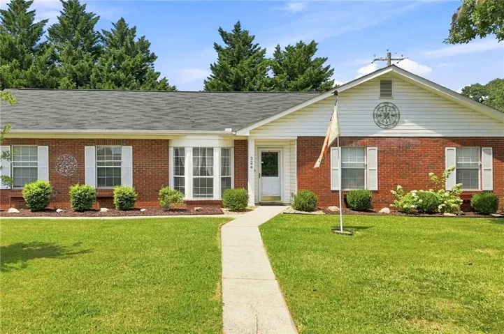 Brick facade with white siding accents and a contrasting dark roof