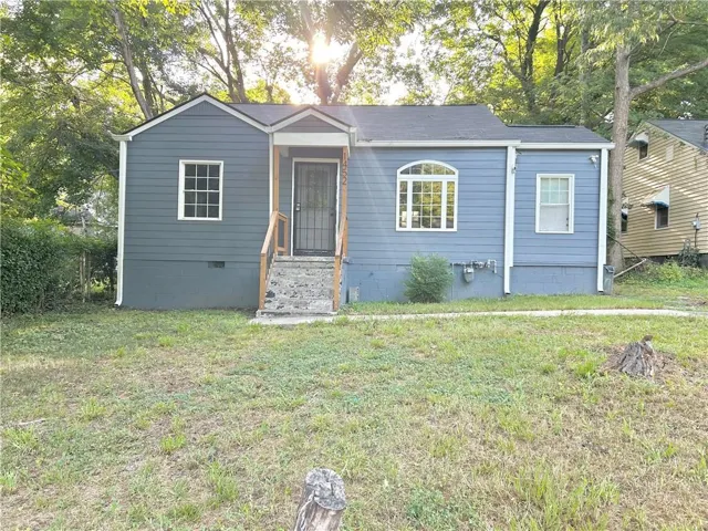 Wood-siding exterior with an arched window, white window trim, and a covered entry