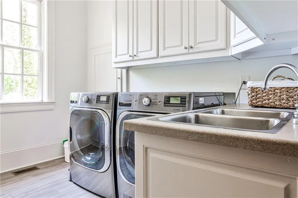 Laundry room with double sinks, storage area and dumbwaiter.