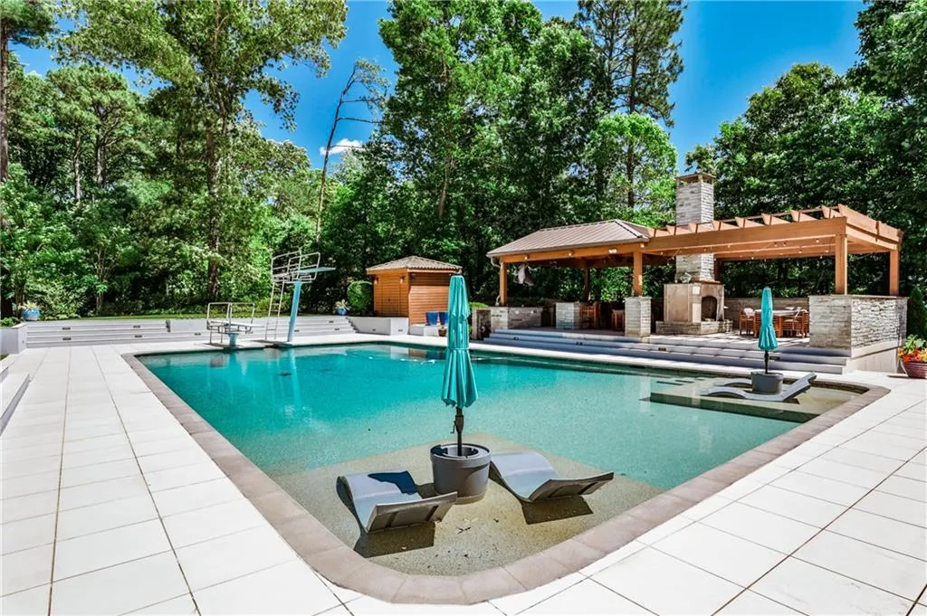 Pool with two tanning ledges, two diving boards, and spectacularly appointed outdoor kitchen with double fireplace.